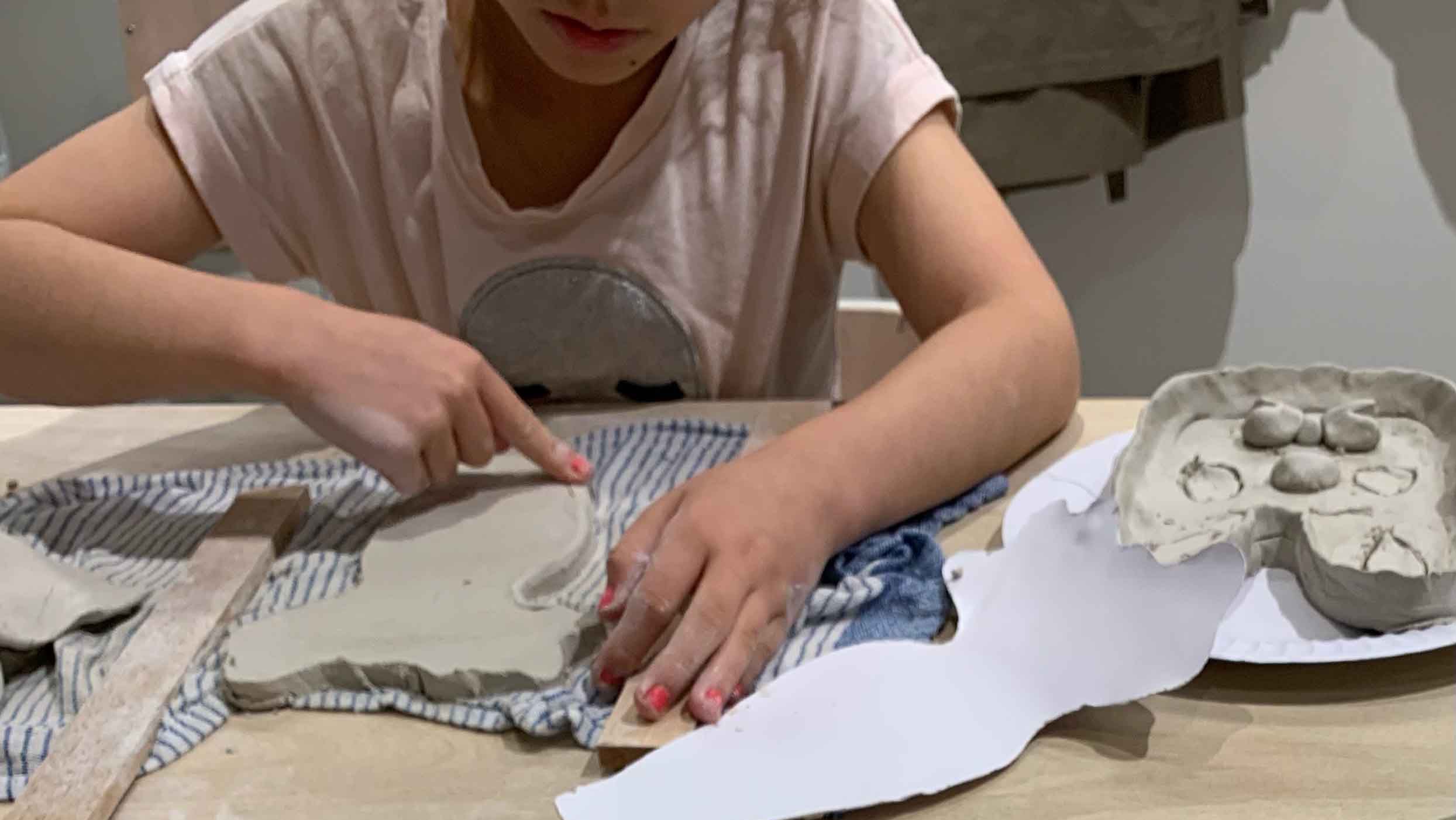 Child working on a rabbit trinket dish from air dry clay.