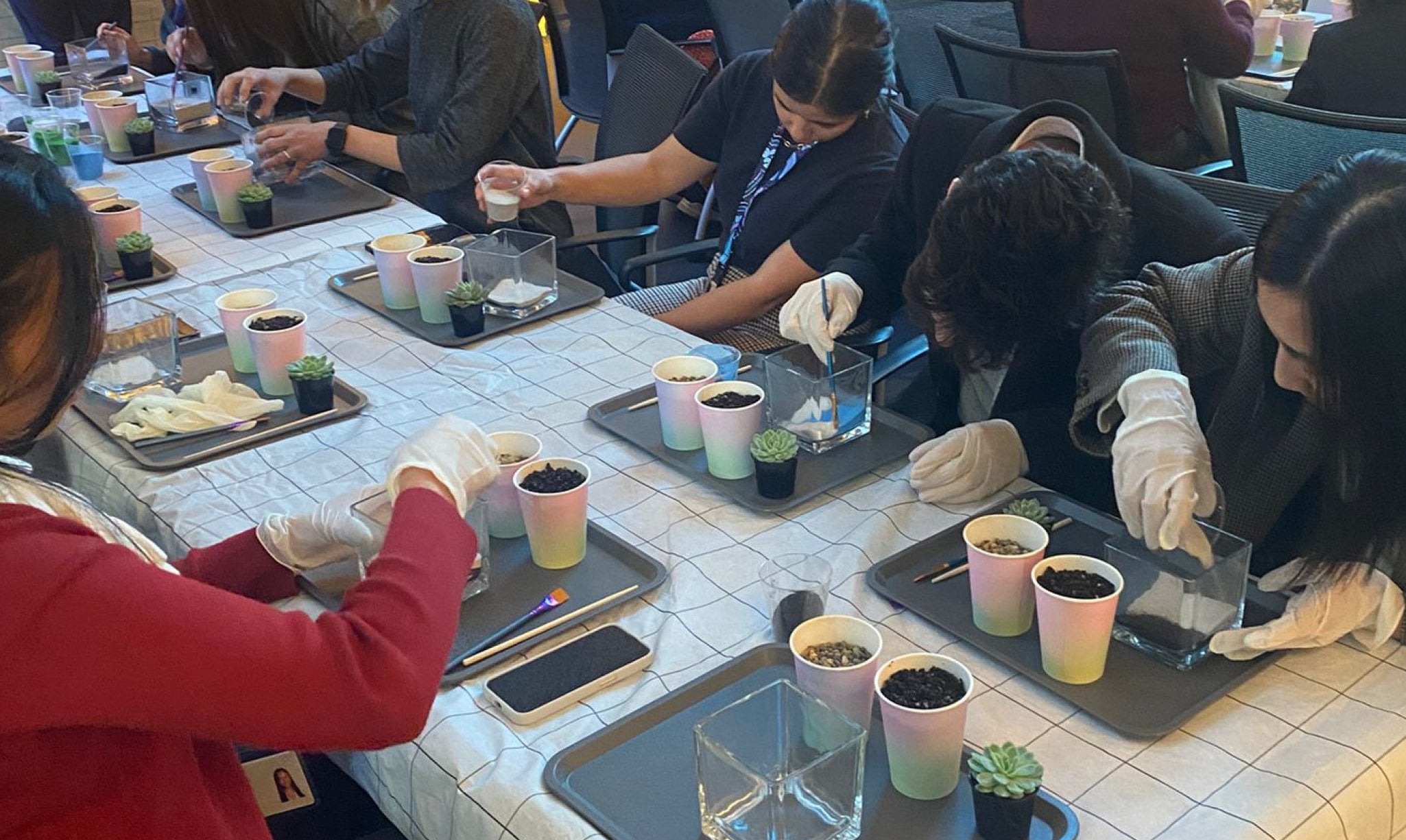 Corporate team activity building terrariums at work.